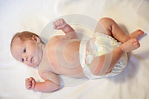 Newborn baby dressed in diaper, lying on a white background