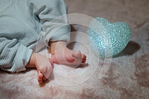 Newborn baby feet in bed close up. Happy Family concept. Beautiful conceptual image of Maternity. Useful as greeting card.