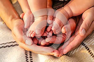 Newborn baby feet in family hands. Symbol of love