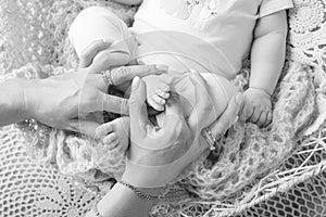 Newborn baby feet in mother hands. Mother holding legs of the kid in hands. Close up image. Happy family concept