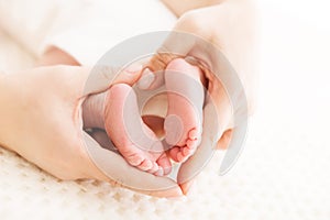 Newborn Baby Feet in Mother Hands, Mom massaging New Born Kid Foot photo