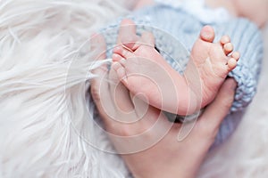 Newborn baby feet in mother hands. Parental love and care