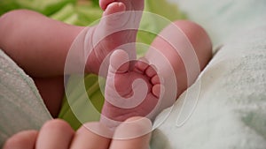 Newborn baby feet. Mother tickles baby heels.