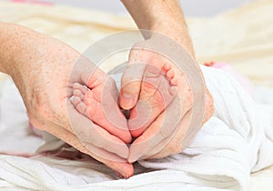 Newborn baby feet in parents hand