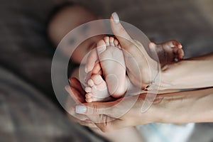 Newborn baby feet parents holding in hands. Love simbol as heart sign. - love sign with baby feet and hands