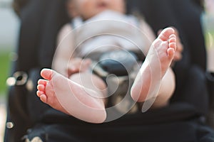 Newborn baby feet sitting in carriage or buggy