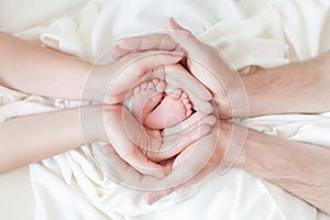 Newborn baby feet in white cloth wrapped in heart, baby life