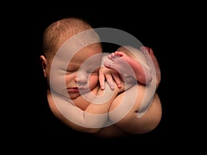 Newborn baby in foetus pose