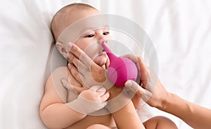 Newborn baby getting nose cleaning with cleaner