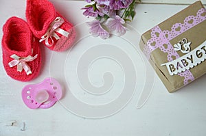 A newborn baby girl background. Newborn accessories for a baby girl on a pink wooden background.