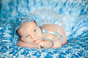 Newborn baby girl in a blue lace bonnet