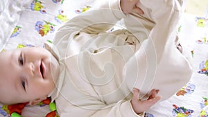 Newborn baby girl boy sneezing smiling and stretching while waking up in own little bed