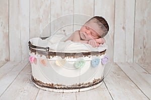 Newborn Baby Girl in a Bucket with Rainbow Heart Garland