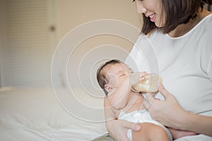 Newborn baby girl is drinking milk by  her mother