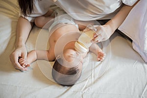 Newborn baby girl is drinking milk by  her mother