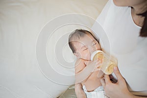 Newborn baby girl is drinking milk by  her mother