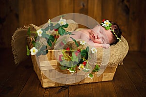 Newborn baby girl has sweet dreams in strawberries