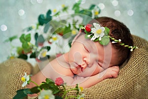 Newborn baby girl has sweet dreams in strawberries