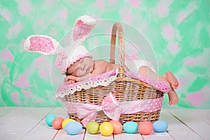 Newborn baby girl in a rabbit costume has sweet dreams on the wicker basket. Easter Holiday