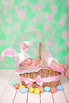 Newborn baby girl in a rabbit costume has sweet dreams on the wicker basket. Easter Holiday