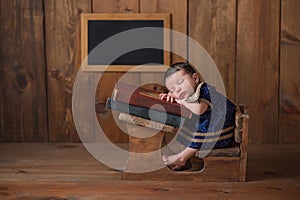 Newborn Baby Girl Sleeping at her School Desk