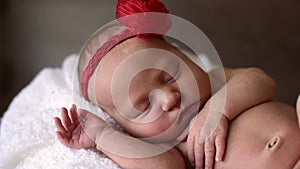 Newborn baby girl sleeping with red headband