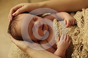 Newborn baby girl sleeping under cozy blanket in basket