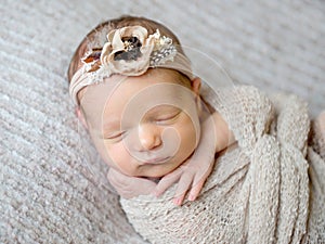 Newborn baby girl swaddled in wrap