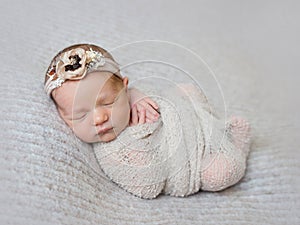 Newborn baby girl swaddled in wrap