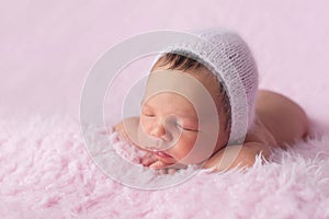 Newborn Baby Girl Wearing a Pink Knitted Bonnet