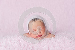 Newborn Baby Girl Wearing a Pink Knitted Bonnet