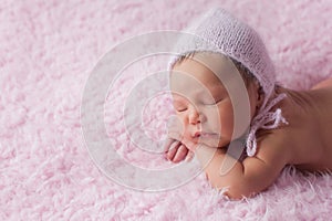 Newborn Baby Girl Wearing a Pink Knitted Bonnet