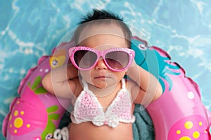Newborn Baby Girl Wearing Sunglasses and a Bikini Top