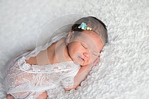 Newborn Baby Girl Wearing a White Lace Romper