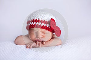 Newborn Baby Girl Wearing a White and Red Crocheted Cap