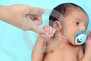 Newborn baby gripping mothers finger