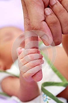 Newborn baby gripping mothers finger