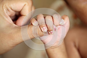 Newborn baby gripping mothers finger