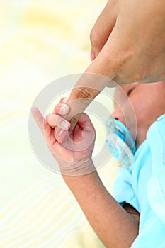 Newborn baby gripping mothers finger