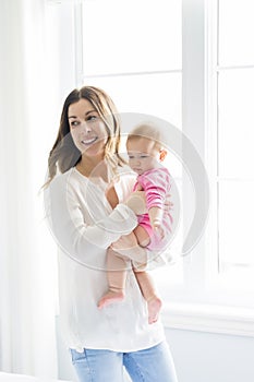 Newborn baby in the hand of his mother at the window