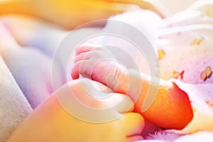 Newborn baby hand in mother`s hands with soft light blue blanket