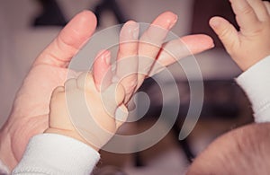 Newborn baby hand playing with adult finger, maternity concept