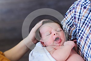 Newborn baby in the hands of his father