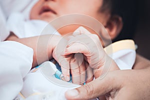 Newborn baby hands holding together while she sleeping