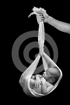 Newborn baby hanging in a sling