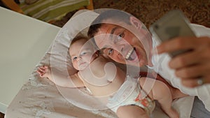 Newborn baby with happy father. Use phone during video call.