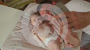 Newborn baby with happy father. Use phone during video call.