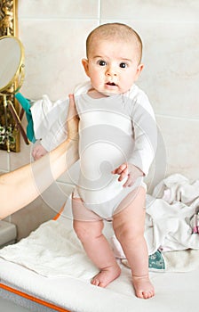 Newborn baby held up stand up thighs photo