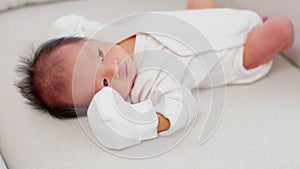 Newborn baby hiccups after feeding milk.Asian newborn lying on white bed and frequently gets hiccups.Newborn Baby Health Care