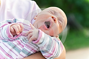 A newborn baby in his mother's arms